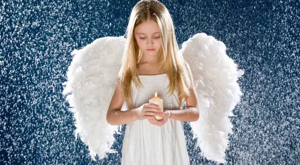 Mała dziewczynka z anielskimi skrzydłami trzyma płonącą świecę. Wokół niej opadają białe płatki, tworząc magiczną atmosferę. To idealne aureolki dla aniołków.