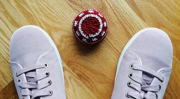 Różowe trampki i czerwono-biała zośka na drewnianej podłodze. Czas nauczyć się, jak się gra w zośkę!